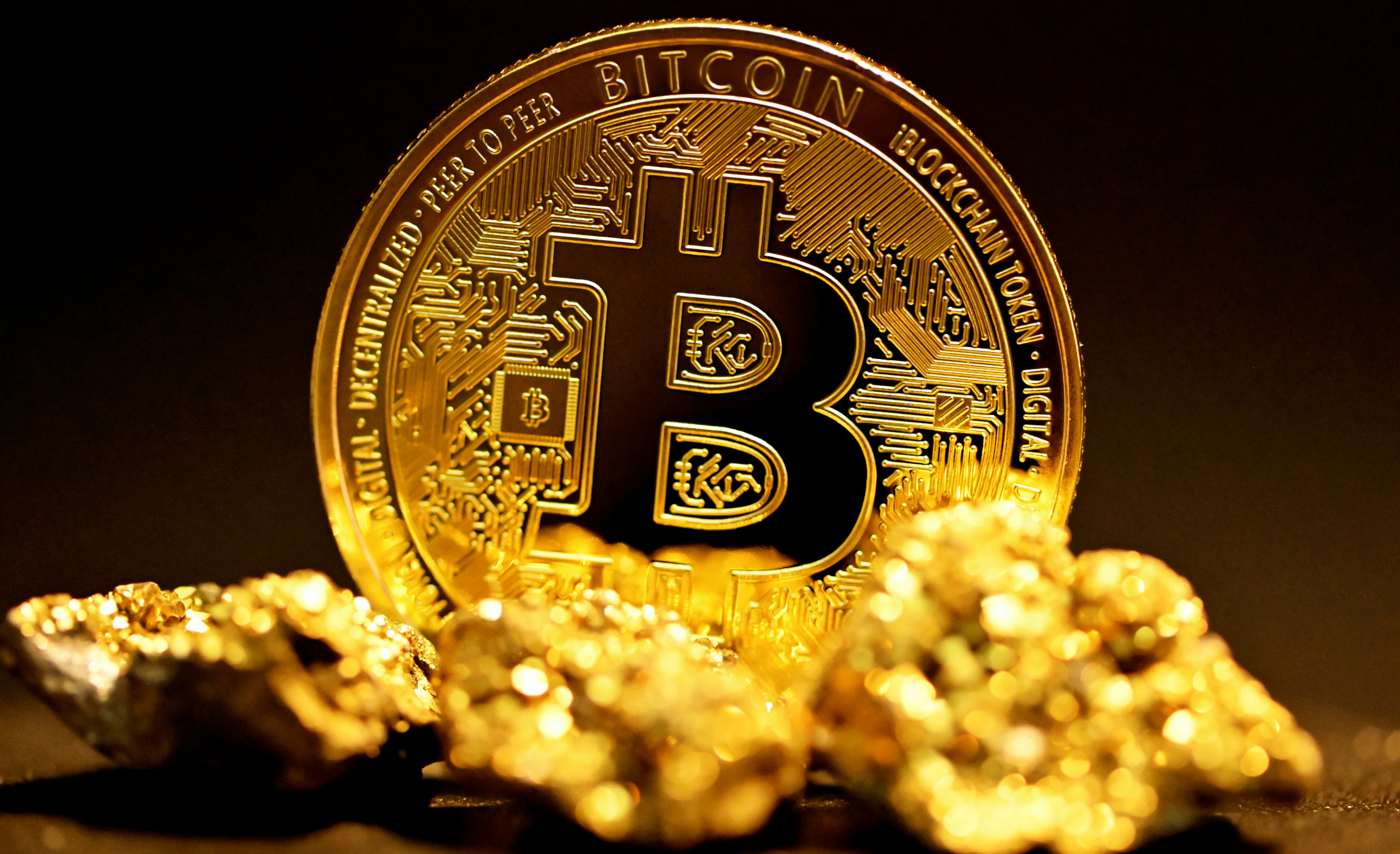 A physical bitcoin token surrounded by gold nuggets