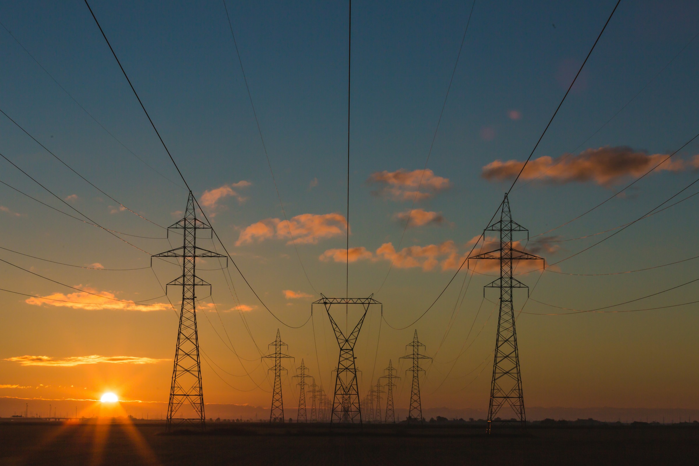 A network of above-ground power lines at sunset